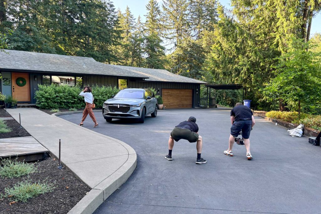 The image shows the photographers filming the Courtesy Lincoln commercial in front of Christie Architecture.