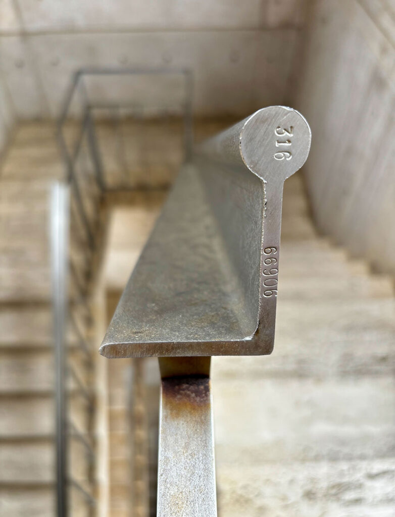 Close up view of a steel stair handrail.