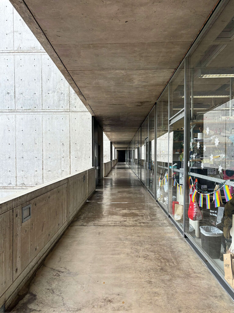 View down an exterior corridor with glass storefront into the labs.