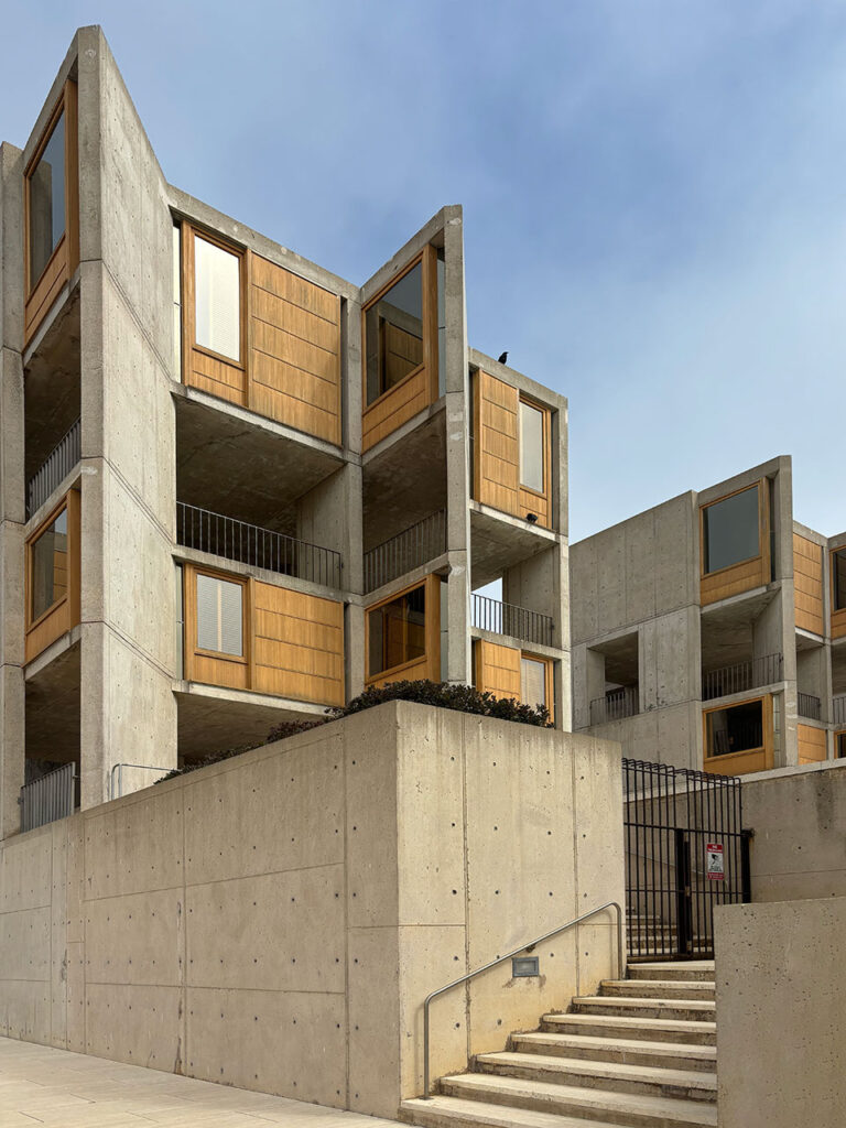 View from the lower patio looking up at a concrete research tower with teak windows.