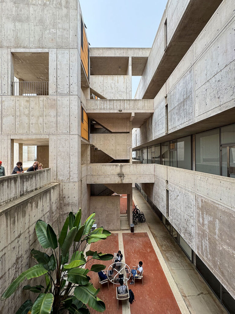 View looking into a recessed light well  with a gathering space at the bottom at the Salk Institute.