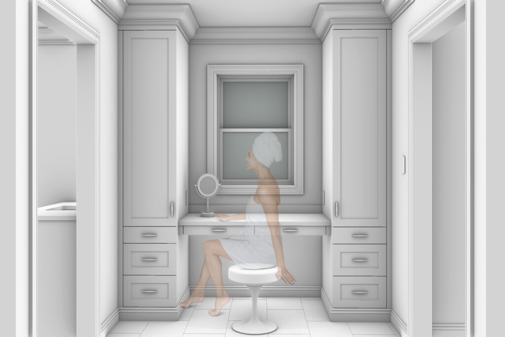 A woman with a towel wrapped around her sits on a stool in the make-up area in this luxury bathroom renovation.